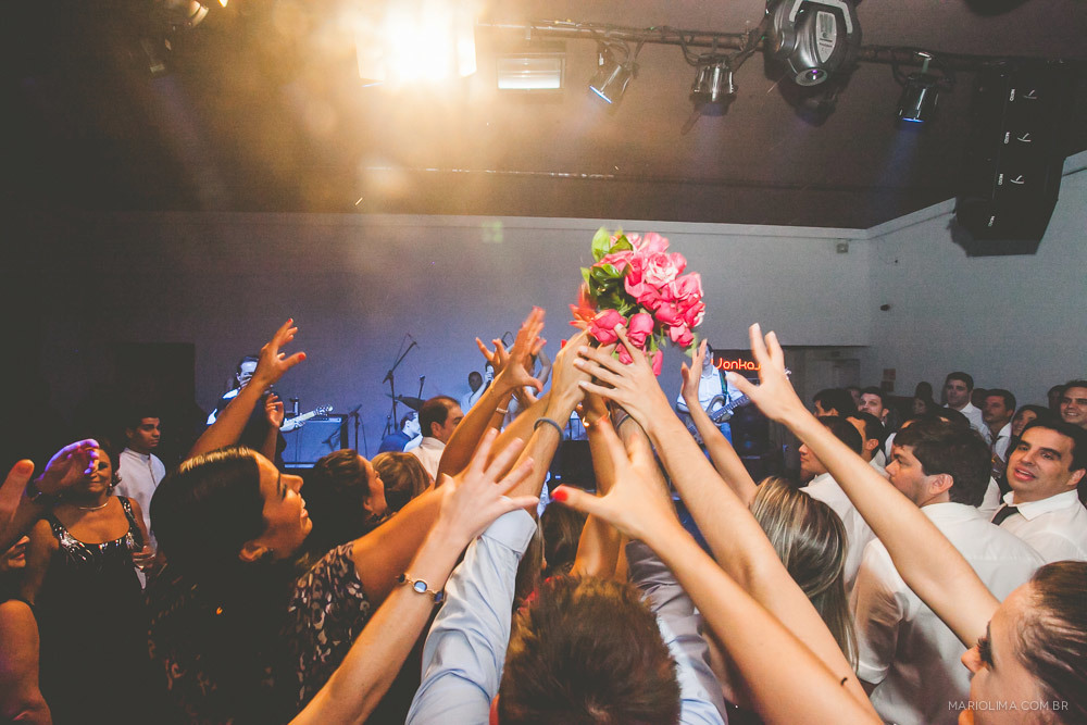 Madrinhas tentando pegar o bouquet da noiva em festa de casamento na Traffô Eventos