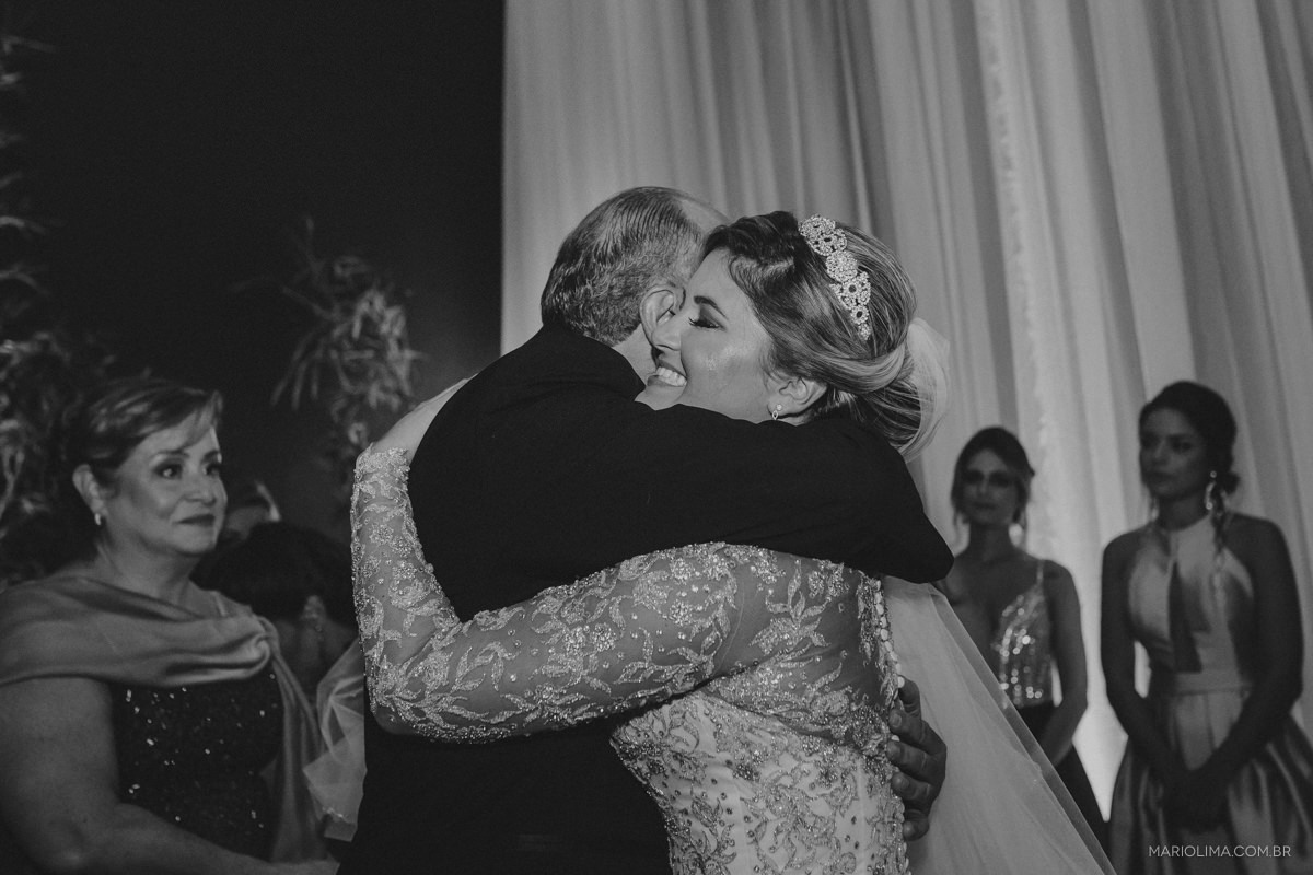 noiva sorrindo abraçando o pai em preto e branco