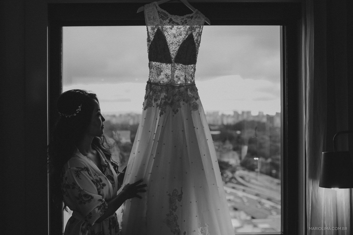 noiva arrumando o vestido na janela do hotel pullman