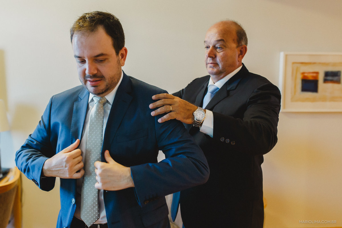 pai arrumando o terno brooksfield do noivo no trip hotel 