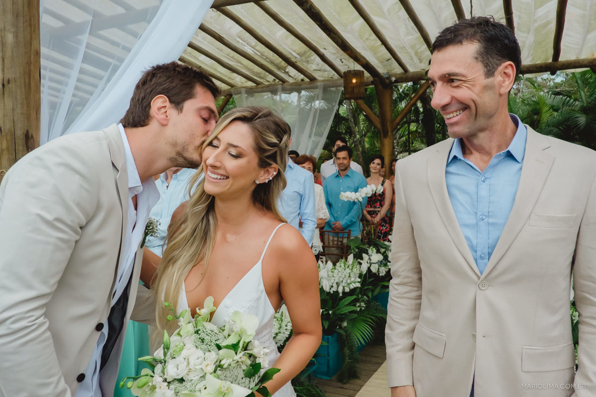 noivo recepcionando a noiva com um beijo 