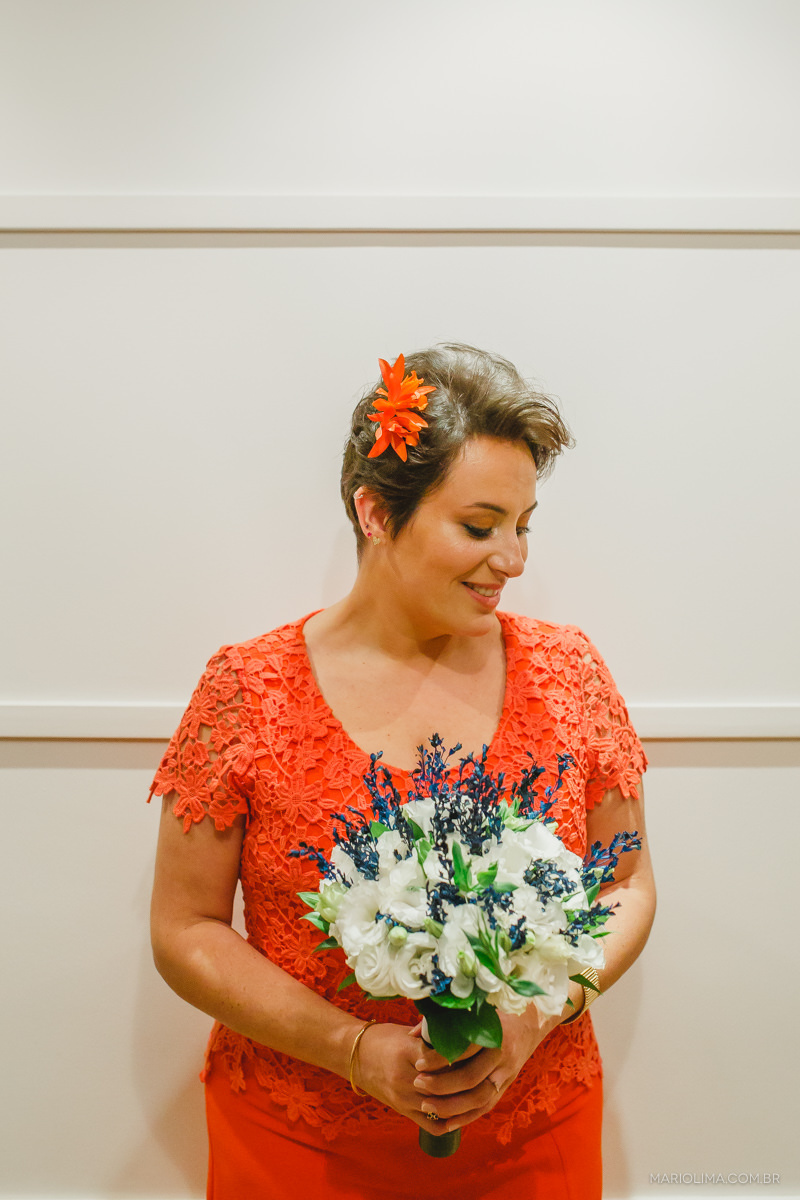 retrato da noiva com seu vestido laranja e uma flor na cabeça