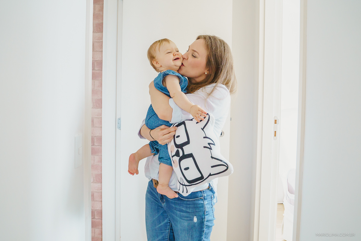 mae beijando bebe no ensaio de familia em casa