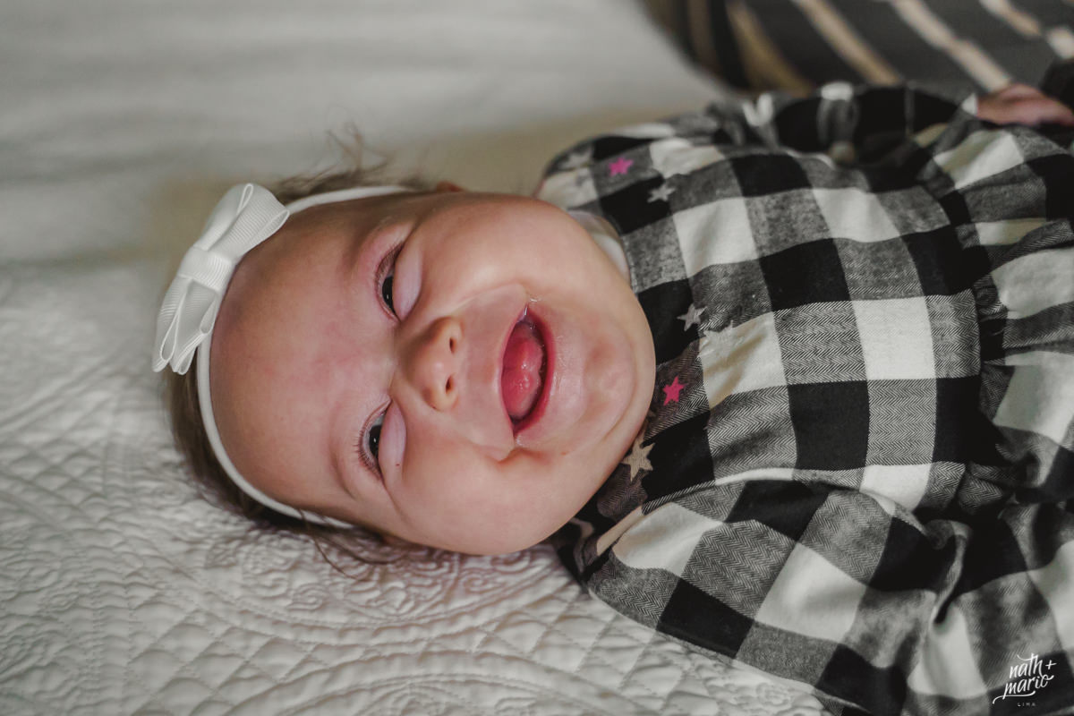 foto de bebe sorrindo deitada na cama