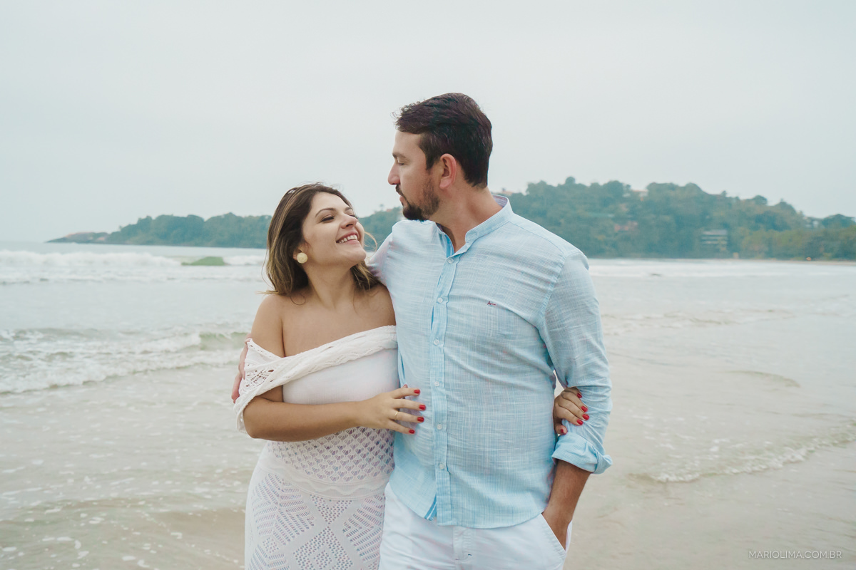 casal andando abraçado no ensaio pre casamento na praia
