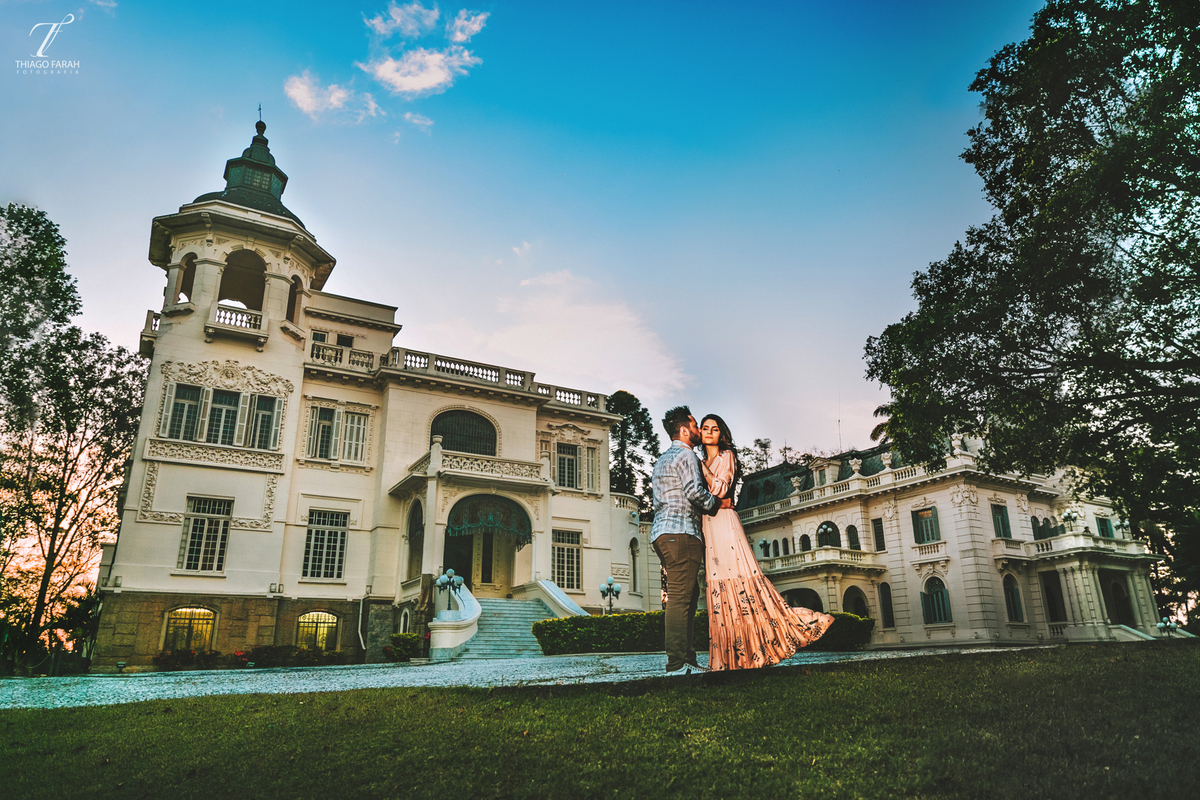 casal abraçado, em frente ao palácio dos cedros, céu azul, no pôr do sol