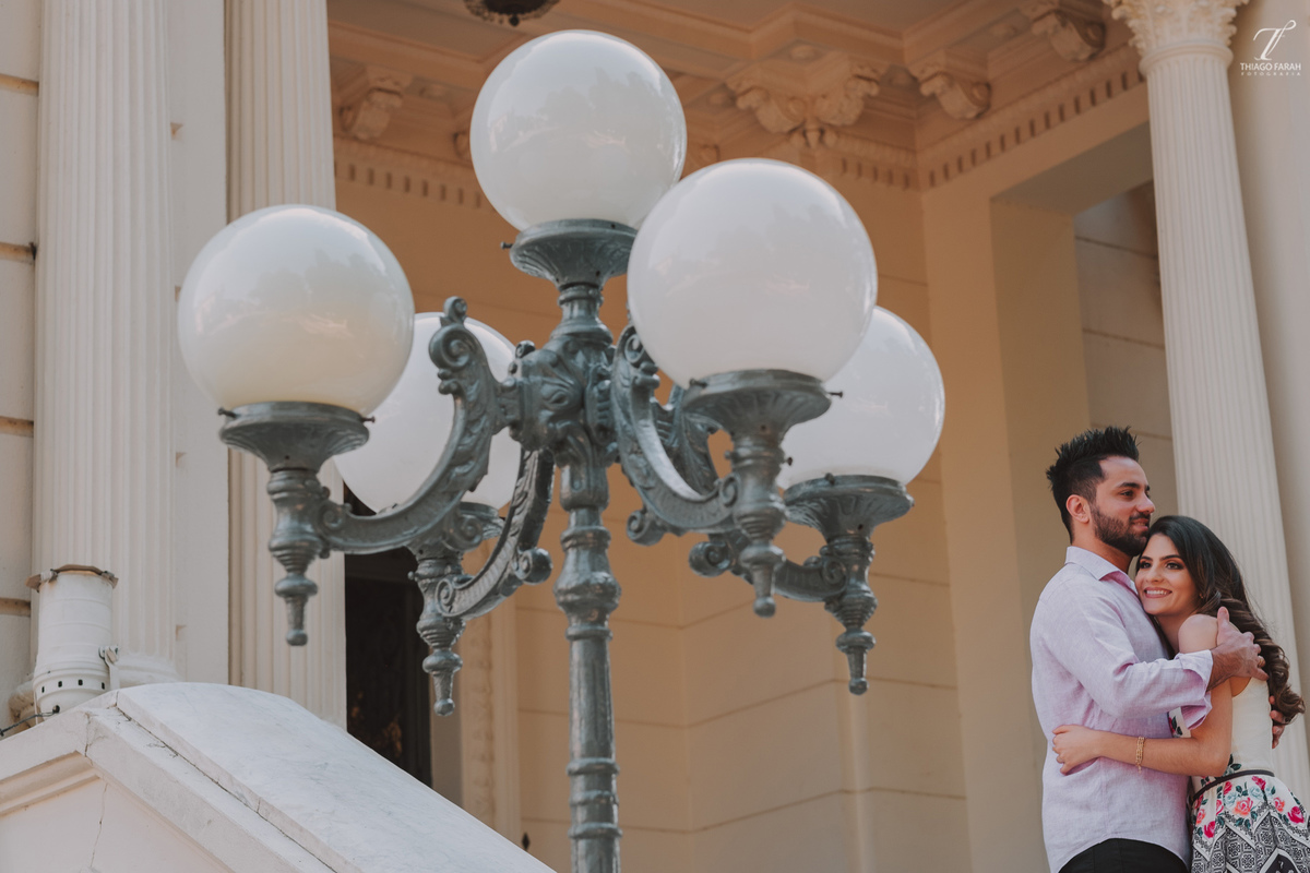casal abraçado na escadaria, do palácio dos cedros, com o lustre ao lado 