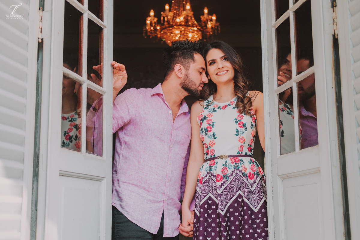 casal juntos abraçados, e mãos dadas, na janela, lustre e arquitetura vitoriana.