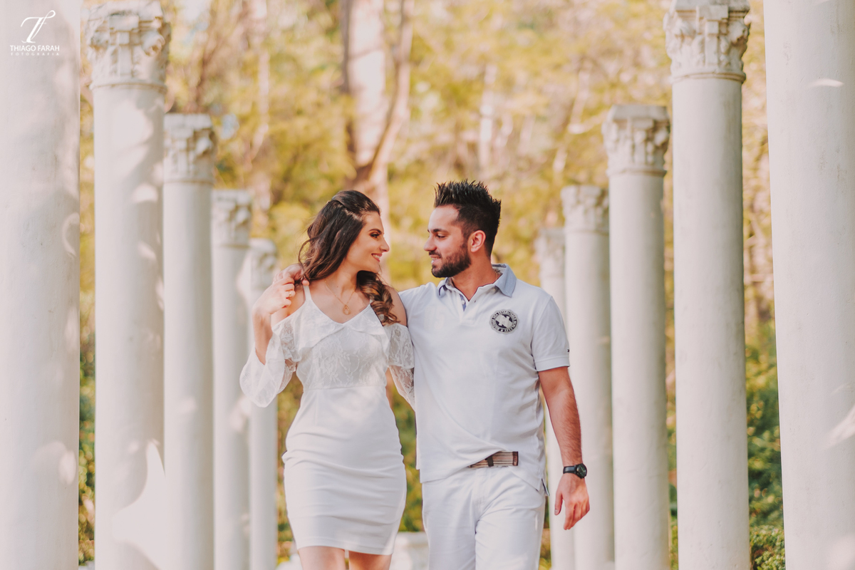 casal andando pelo corredor de pilares, no jardim
