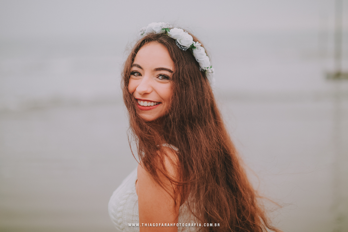 ensaio externo 15 anos em santos, jardim do aquário, ponta da praia, estido branco rendado, coroa de flores, muretas de santos, mar, pedras, nublado, close