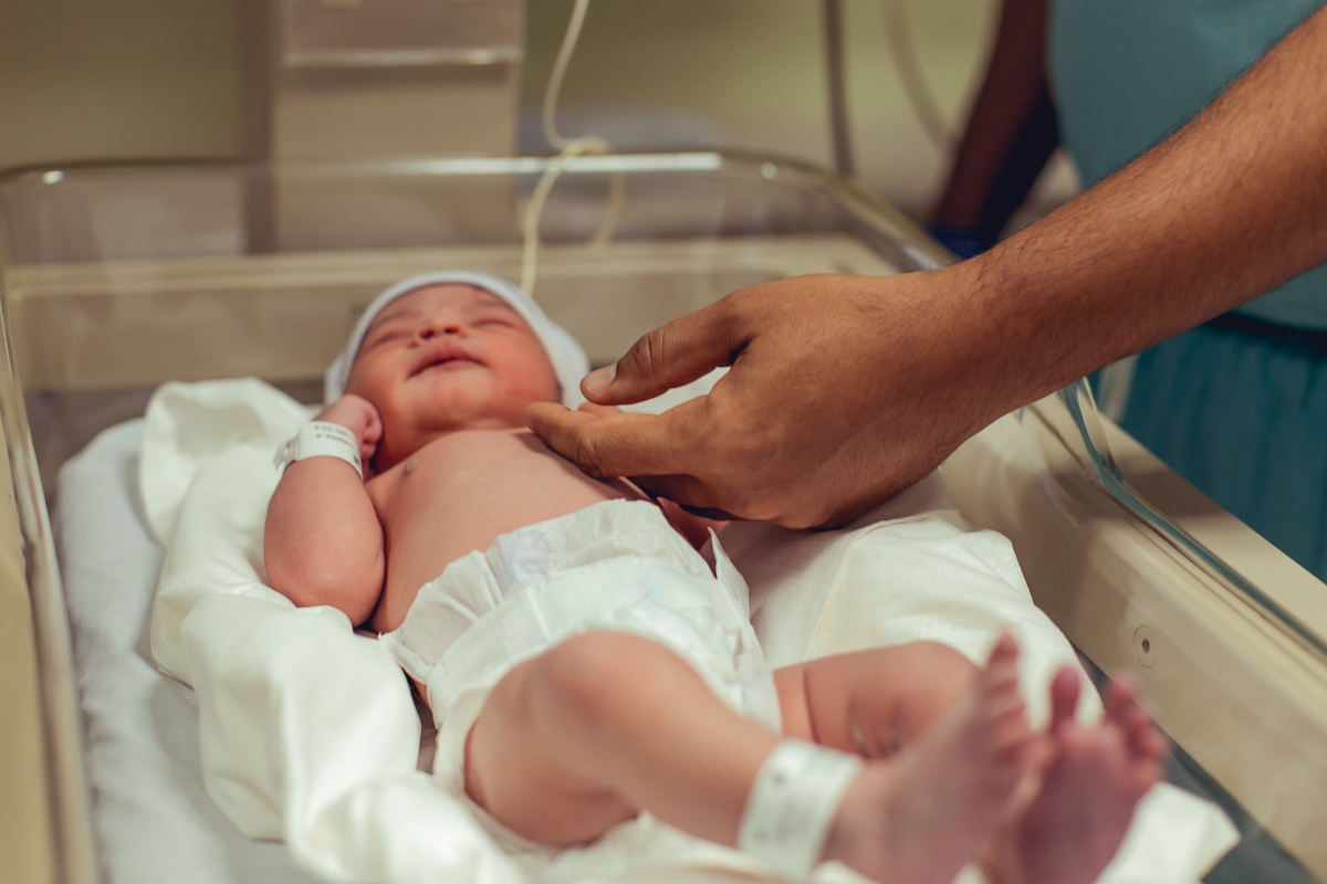 pai faz carinho na filha recem nascida
