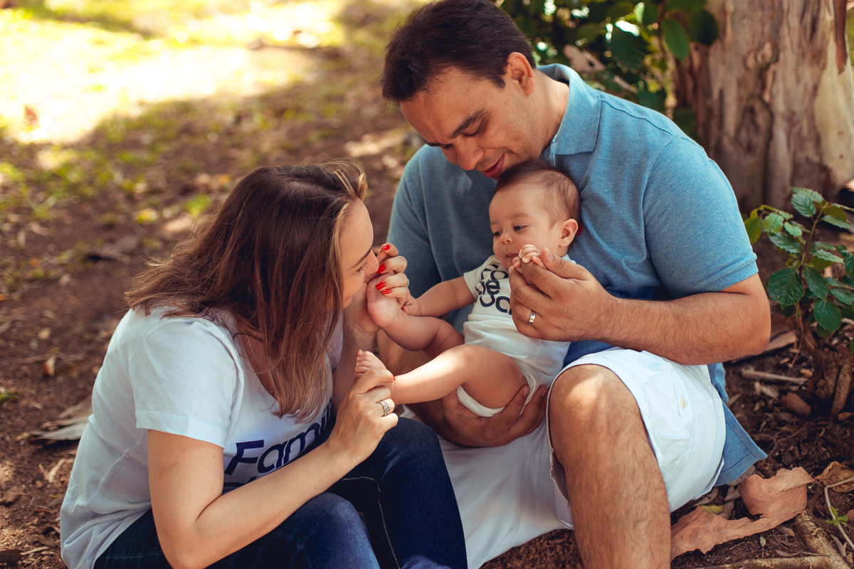 pai mae e filho brincam durante ensaio fotografico