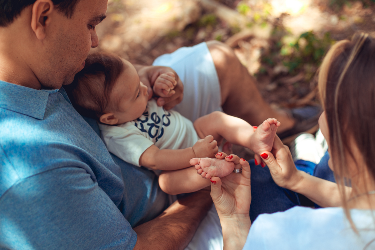 mae brinca com os pezinhos do filho em ensaio infantil
