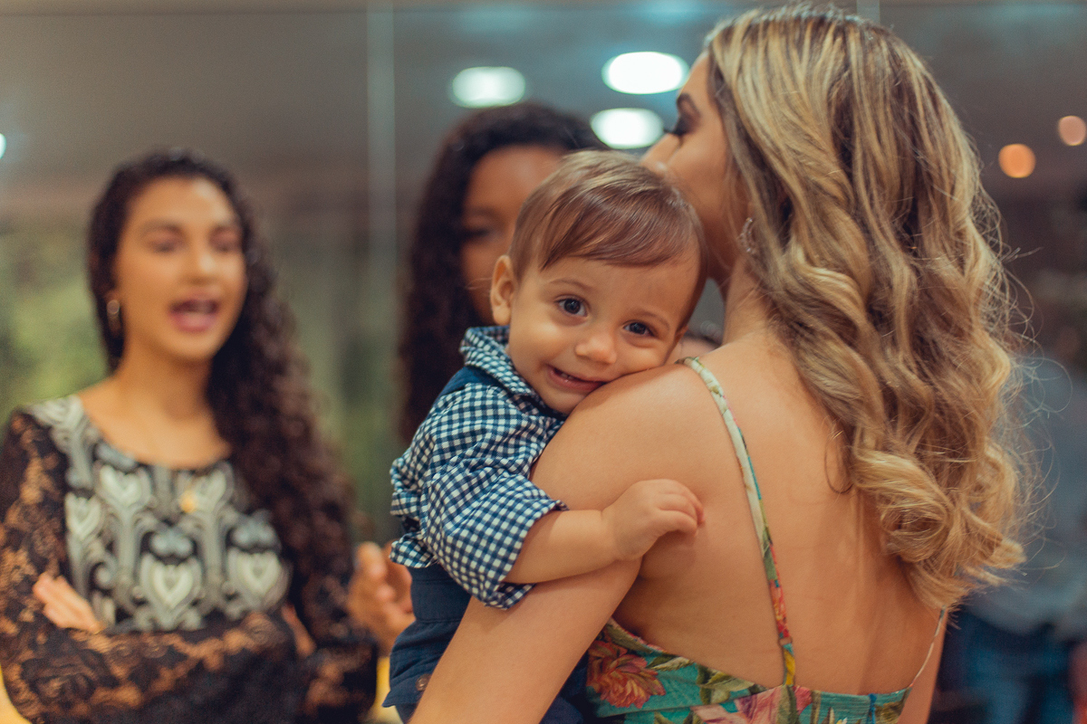 fotografia do bebe no colo da mae na sua festa de 1 ano