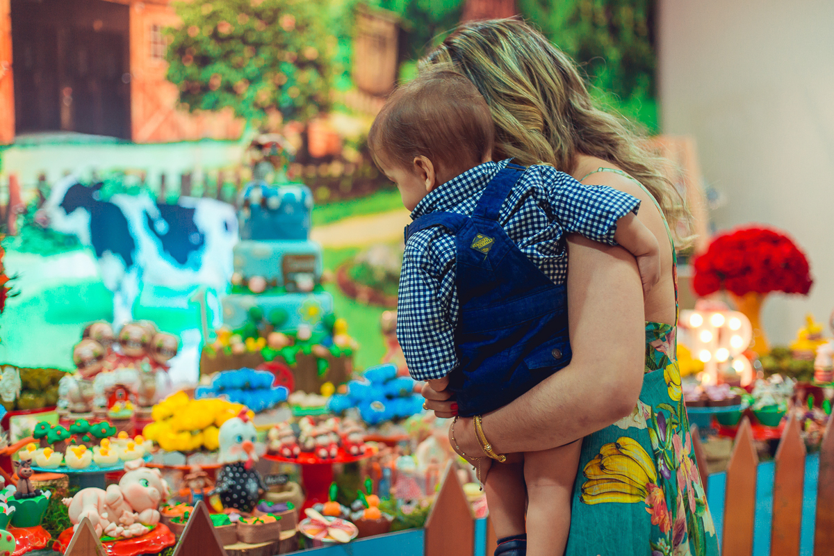 mae e filho admirando a decoração da festa infantil tema fazendinha