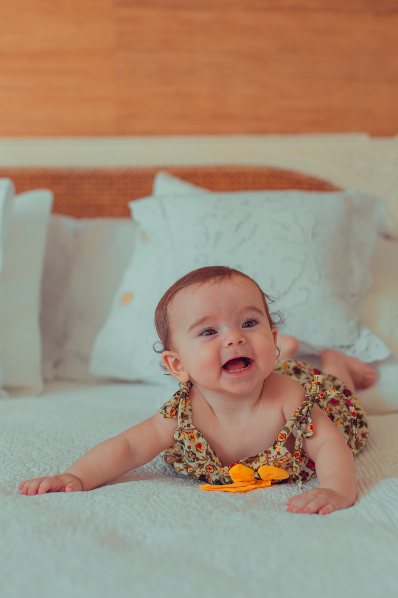 bebe sorrindo na cama dos pais durante ensaio fotografico em salvador