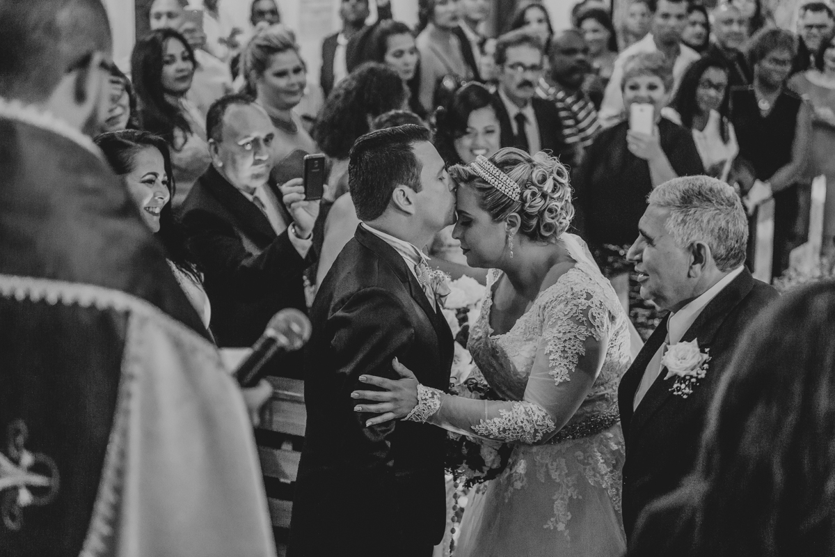 noivo beijando a testa da noiva em casamento 