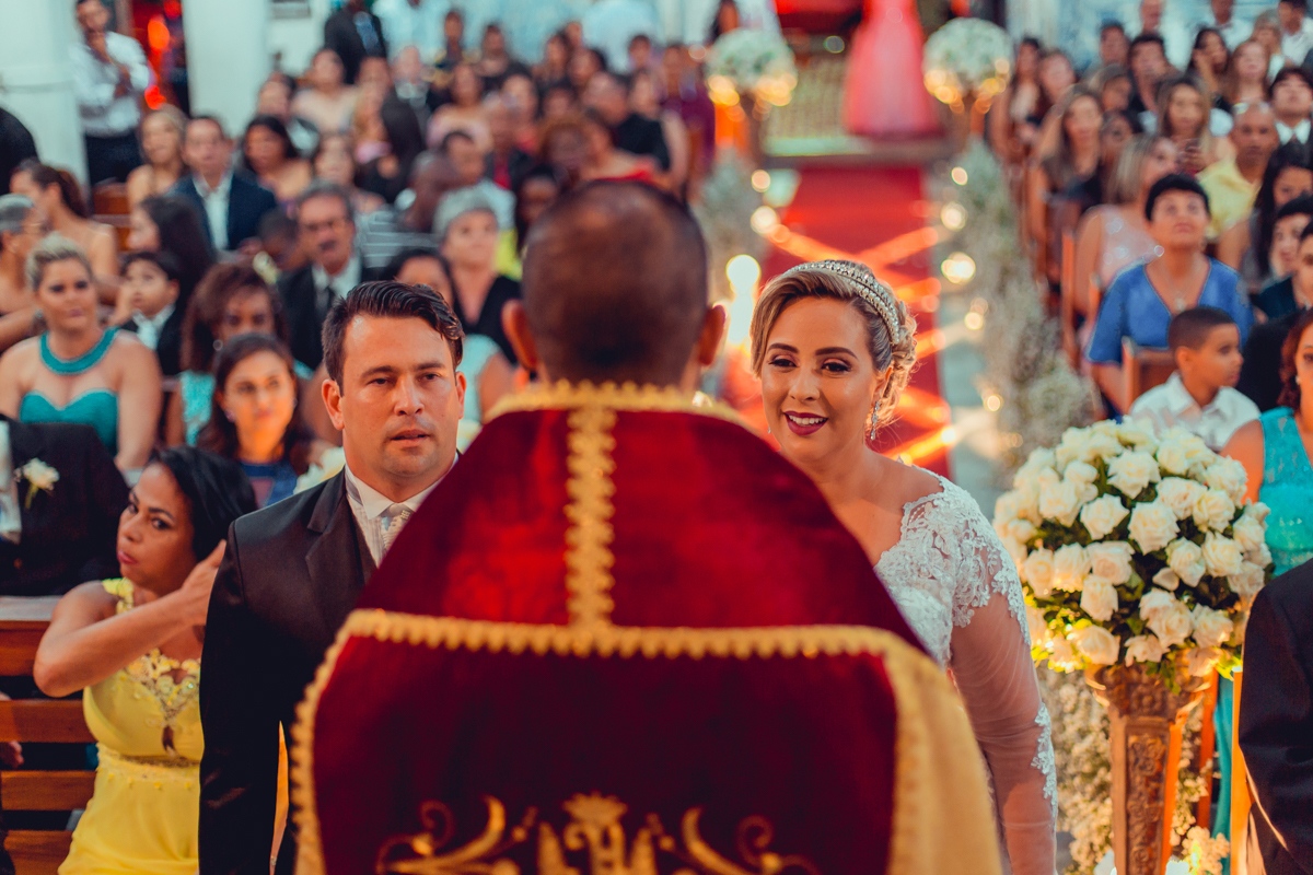 noivos recebendo os votos do padre no alta da igreja