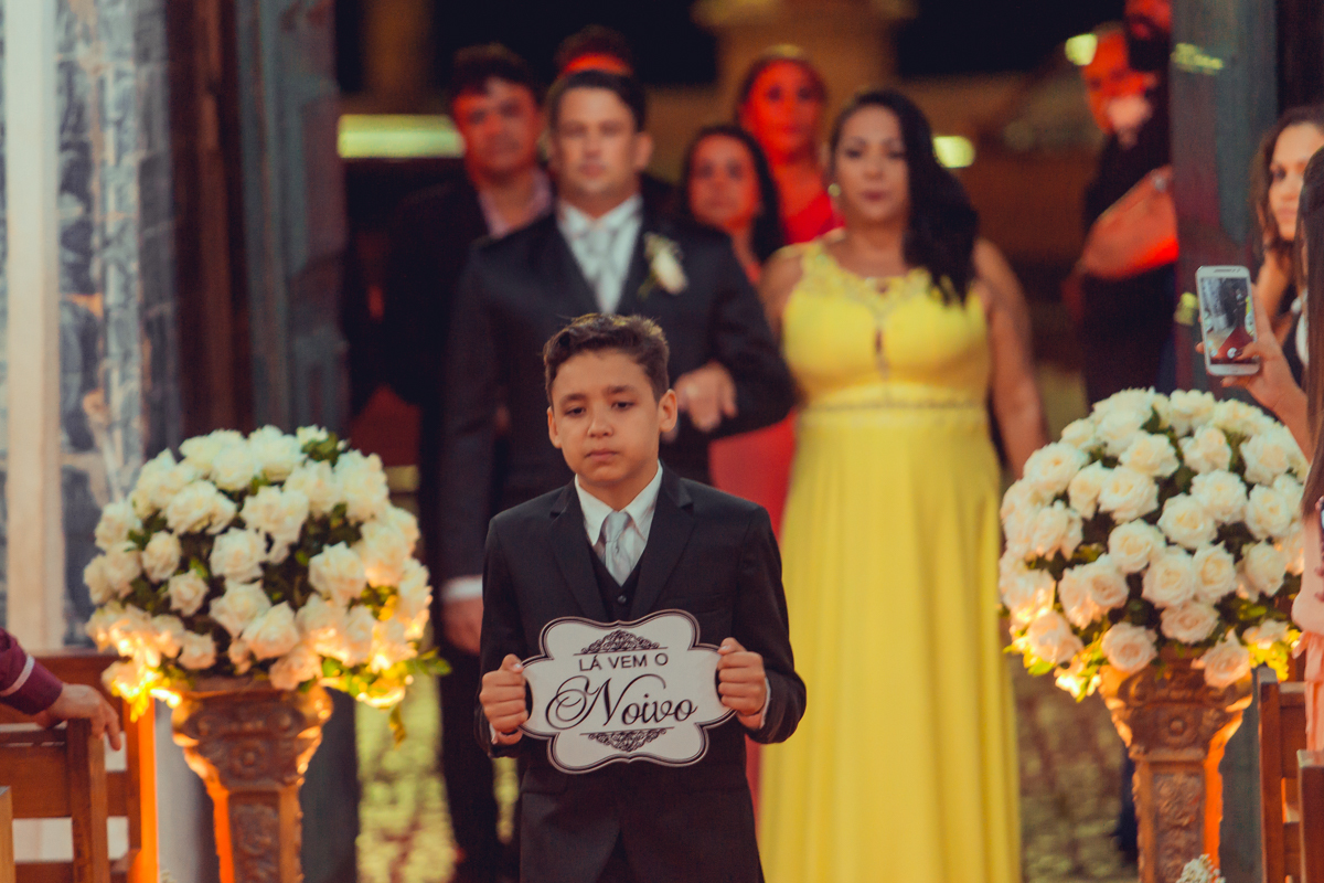 criança entra segurando placa la vem o noivo