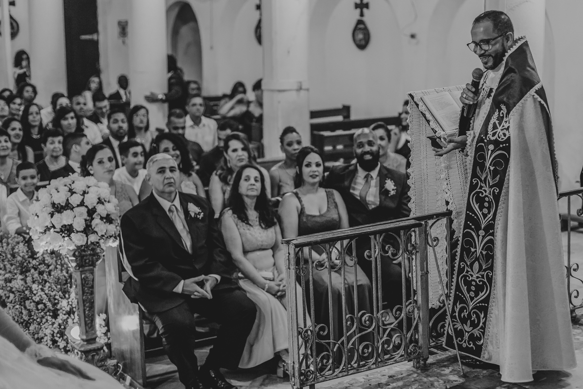 padre fazendo brincadeira com os noivos no altar da igreja