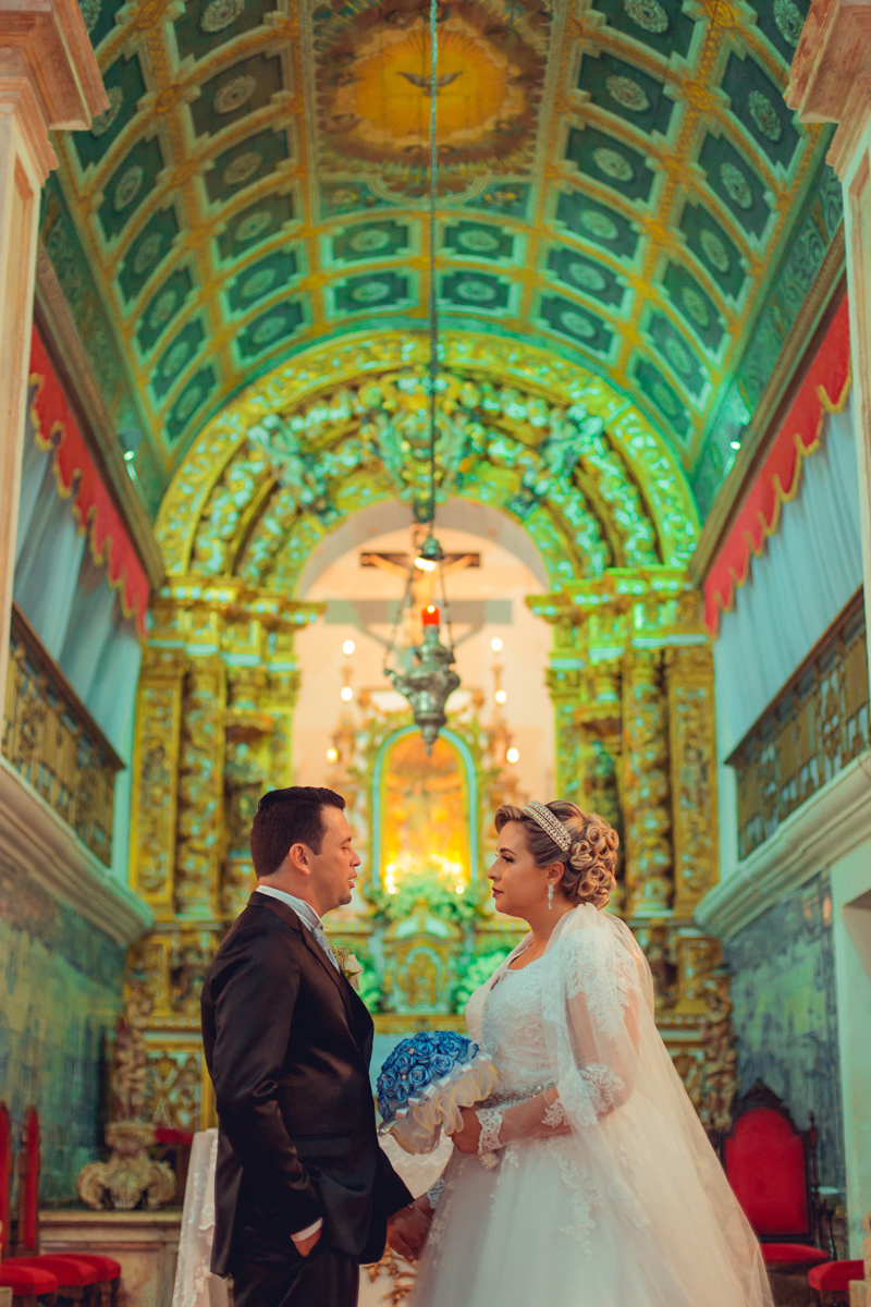 casal de noivos comemorando o casamento no altar da igreja da cidade baixa