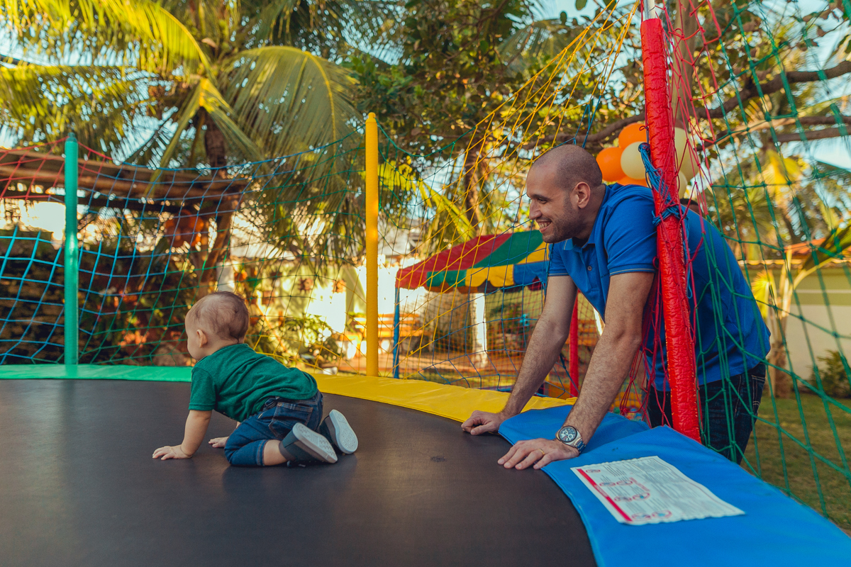 pai brincando com filho no pula pula