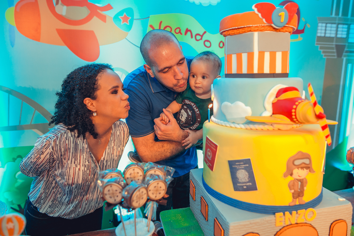 pai e  mae asoprando velinha de bolo em festa de aniversario