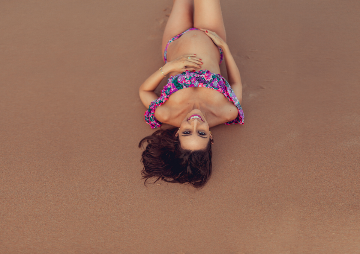 camila rabello deitada na areia da praia de busca vida