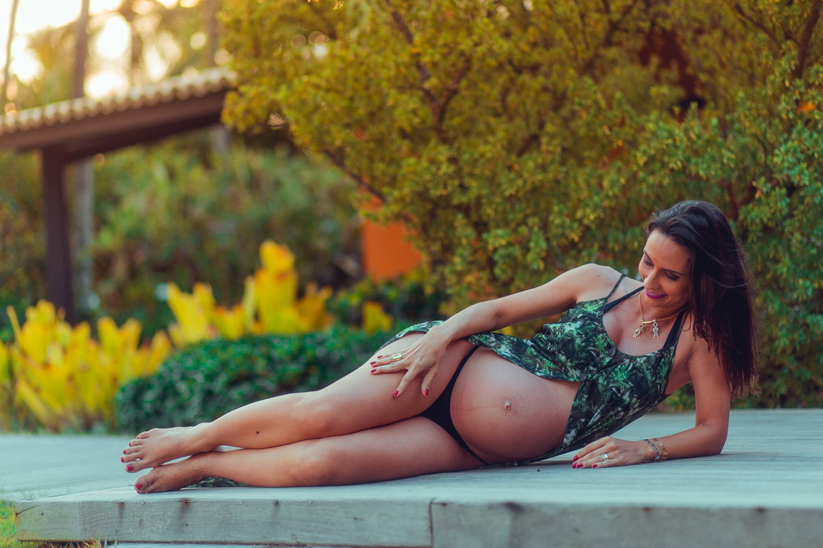 camila rabello deitada na praia de busca vida durante ensaio gestante