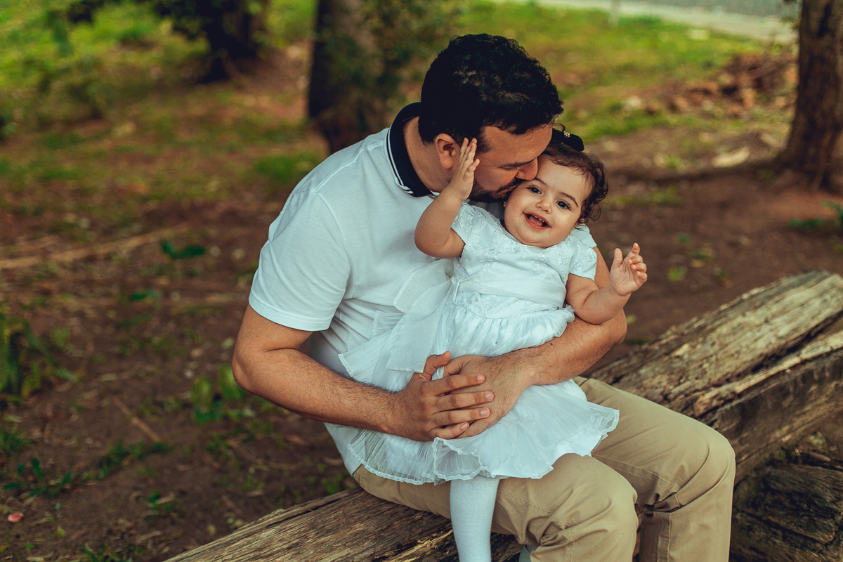 pai beija filha em sessao de fotos na praca dos eucaliptos