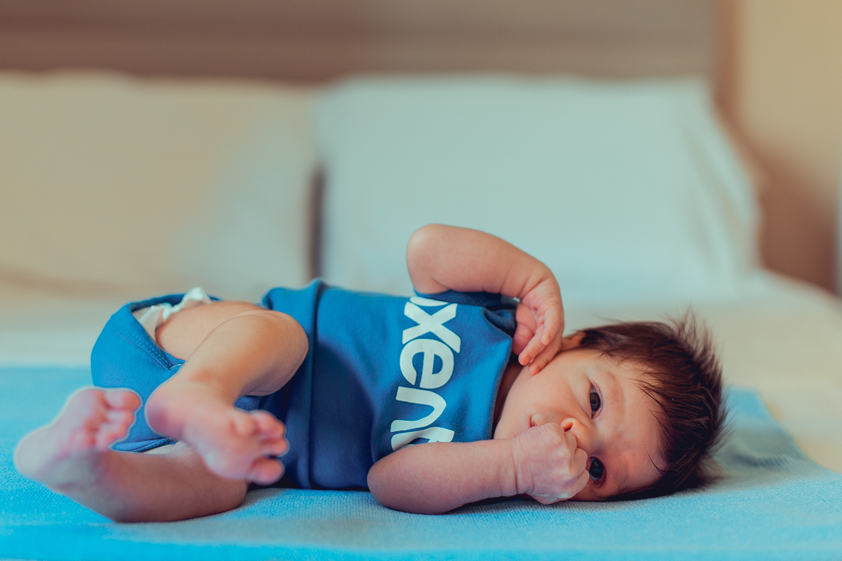 bebe brinca na cama dos pais durante sessao de fotos