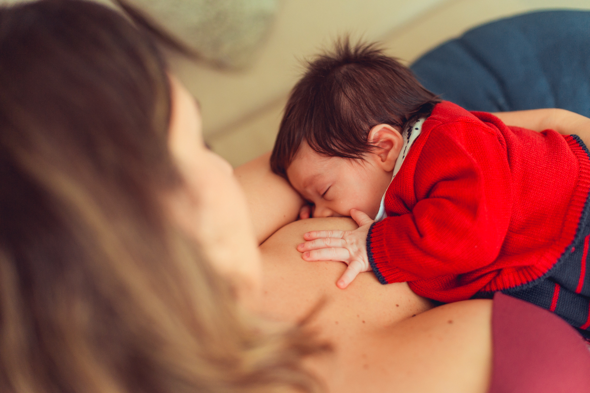 bebe amamentando com saida de maternidade vermelha e azul em salvador