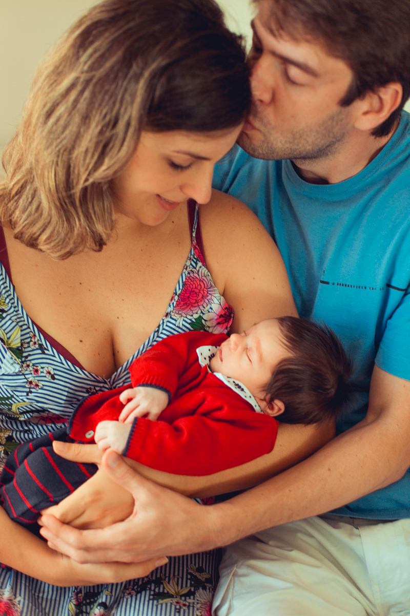 familia admira bebe recem nascido durante ensaio newborn lifestyle