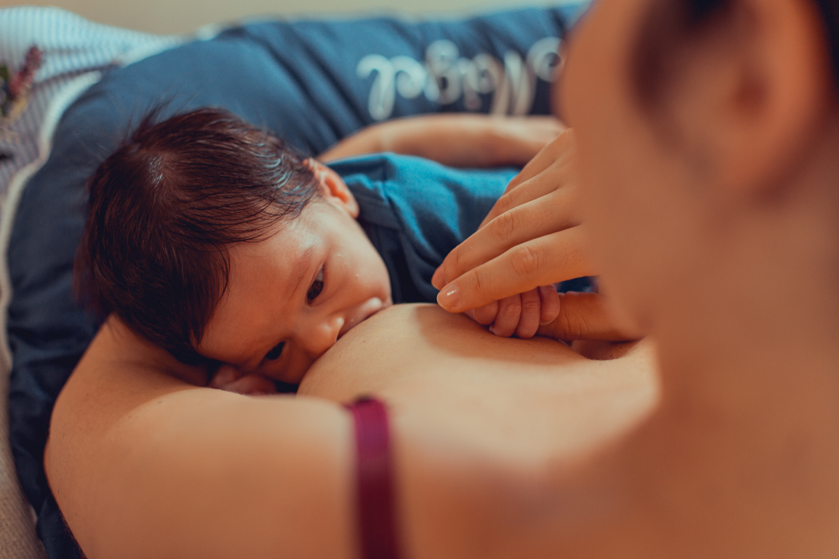 mae amamentando bebe durante sessão de fotos ensaio newborn