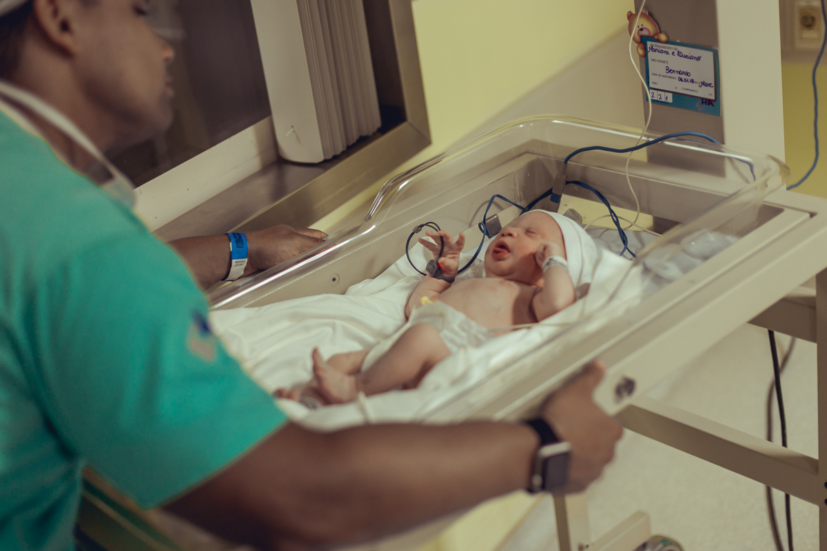 pai conversa com filho no berçario do hospital aliança