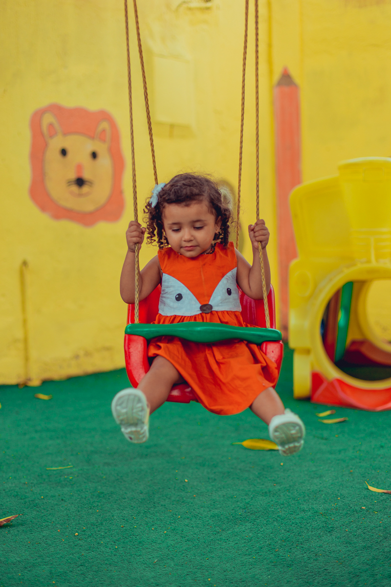 Aniversariante brincando em balanço na escola
