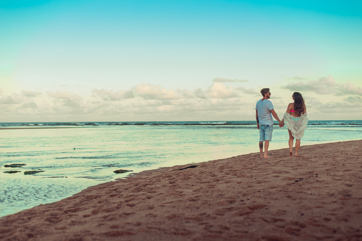 ensaio gestante salvador caminhando na areia da praia ao lado do esposo