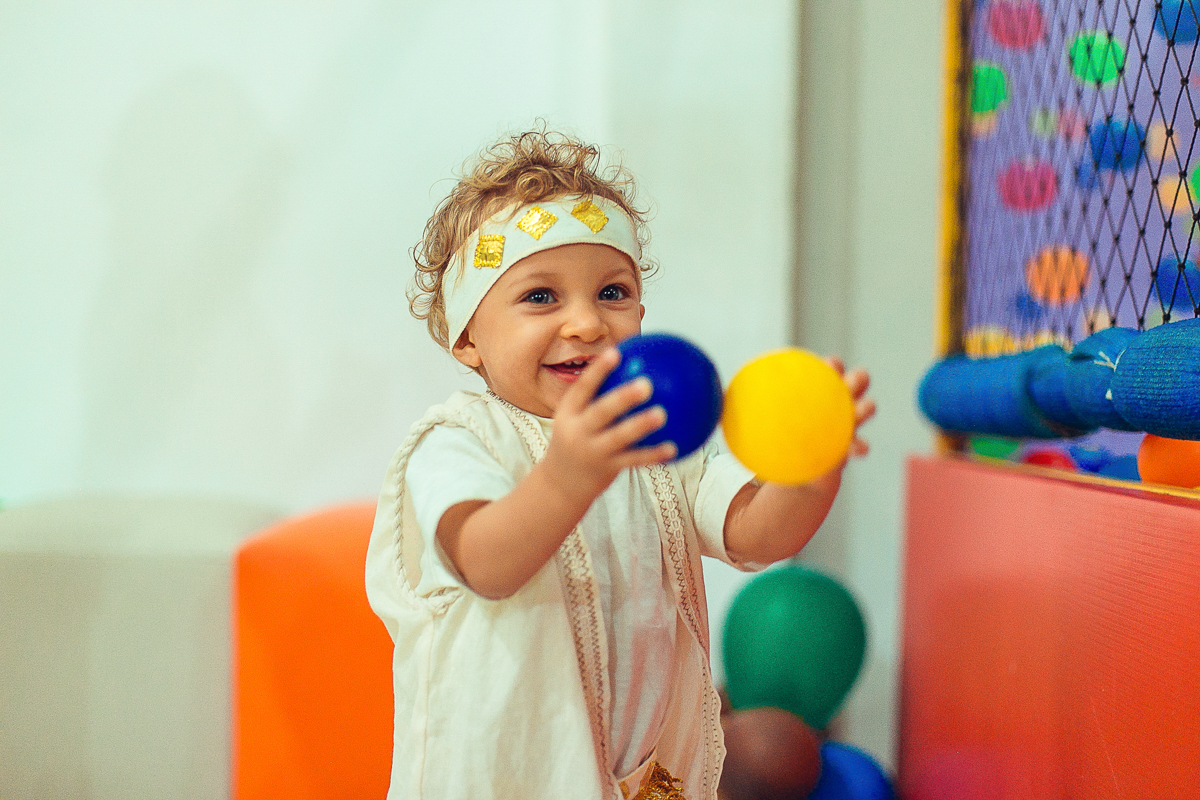 Brincando com bolas coloridas em seu aniversario de um ano