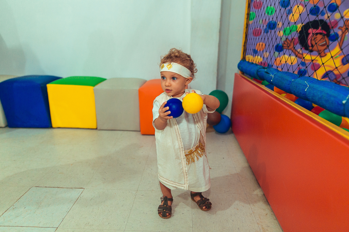Brincando com bolas coloridas em seu aniversario de um ano na estrada do coco