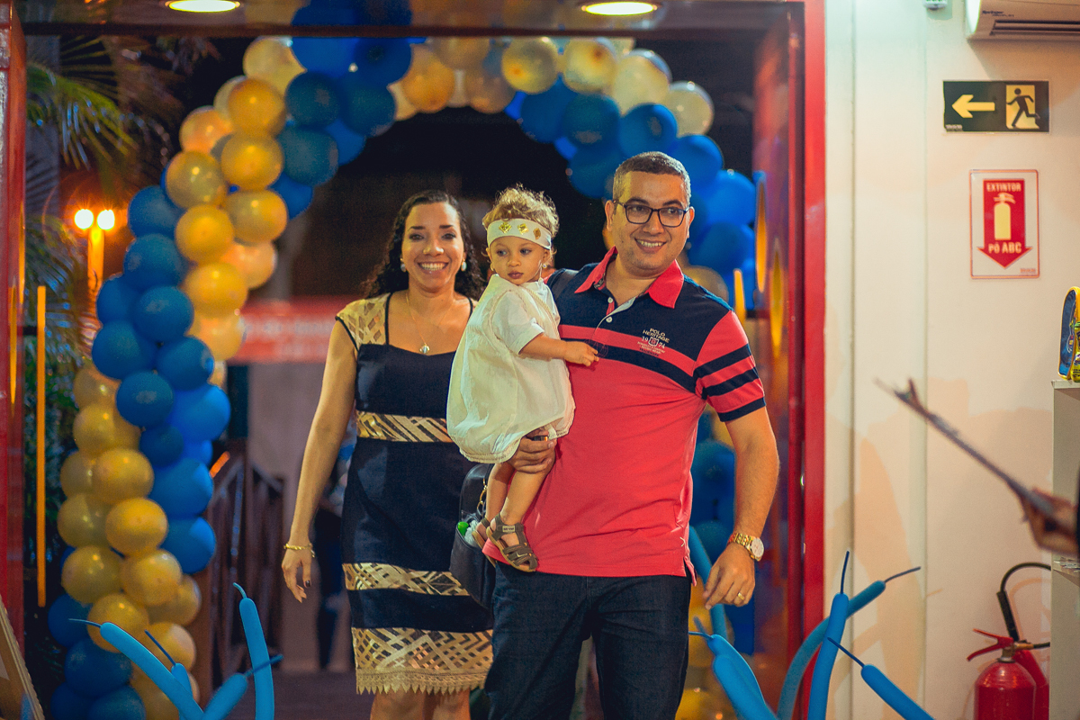 pai mae aniversariante chegando no espao de festas decorado com o tema DAniel na cova dos leões