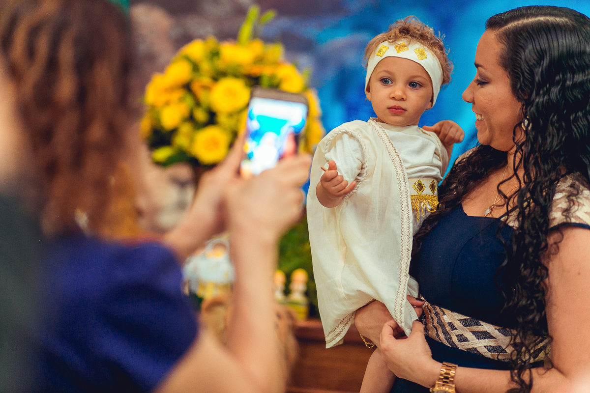 mae e filho sendo fotografados com o celular na festa de 01 ano