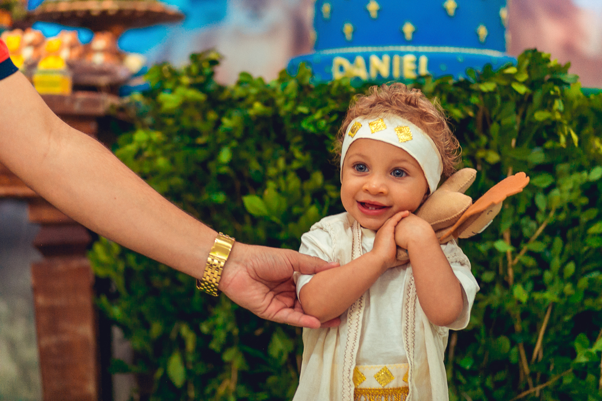 aniversariante abracando o leozinho de feltro da decoração do sua festa