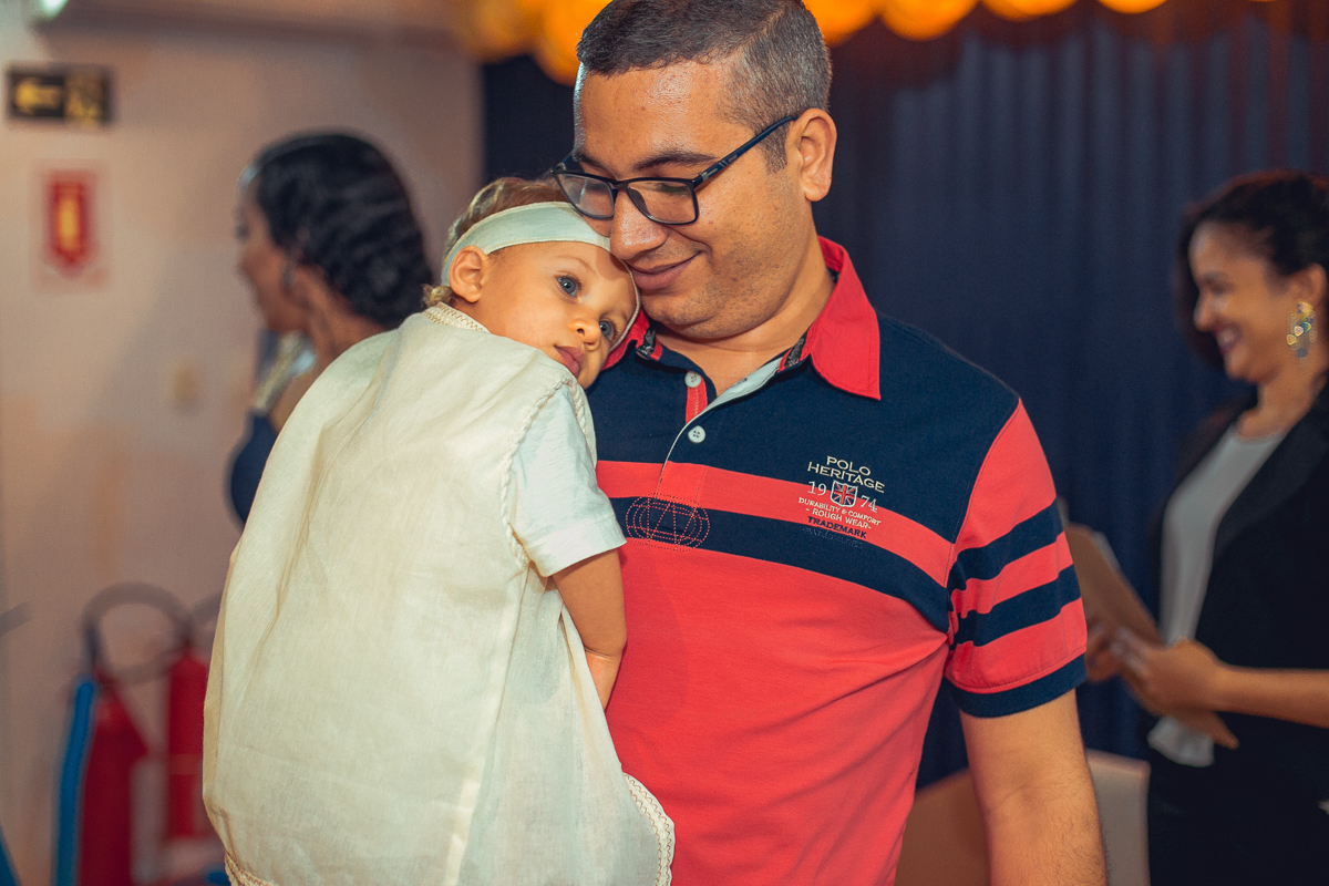 filho deitado no peito dopai em festa de um ano na estrada do coco.