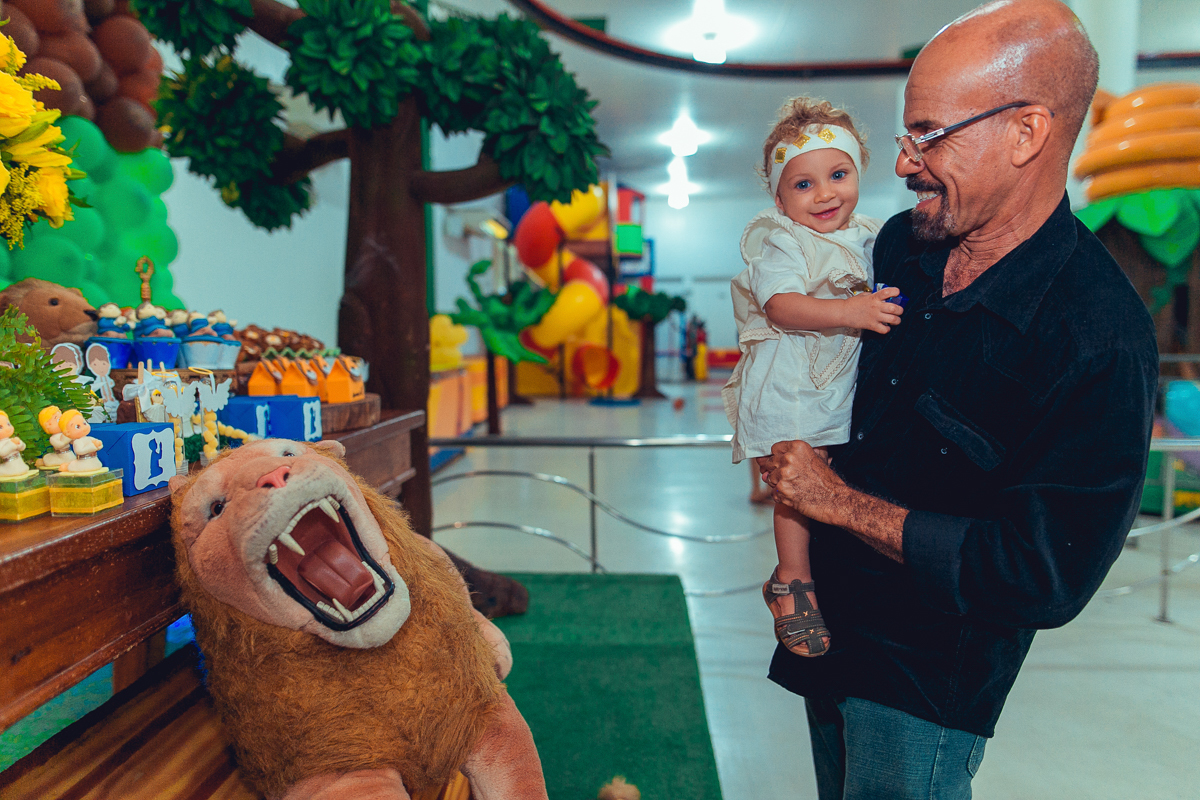 Aniversariante sorrindo em sua festa de um ano no espaço de festa terra do nunca