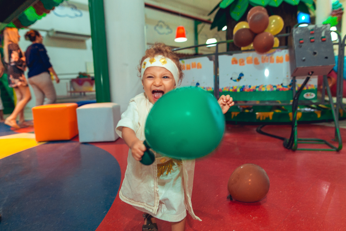 Aniversariante correndo com seu balao de festa decorativa