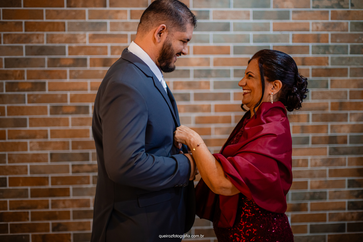 o noivo e sua mãe arrumando a roupa