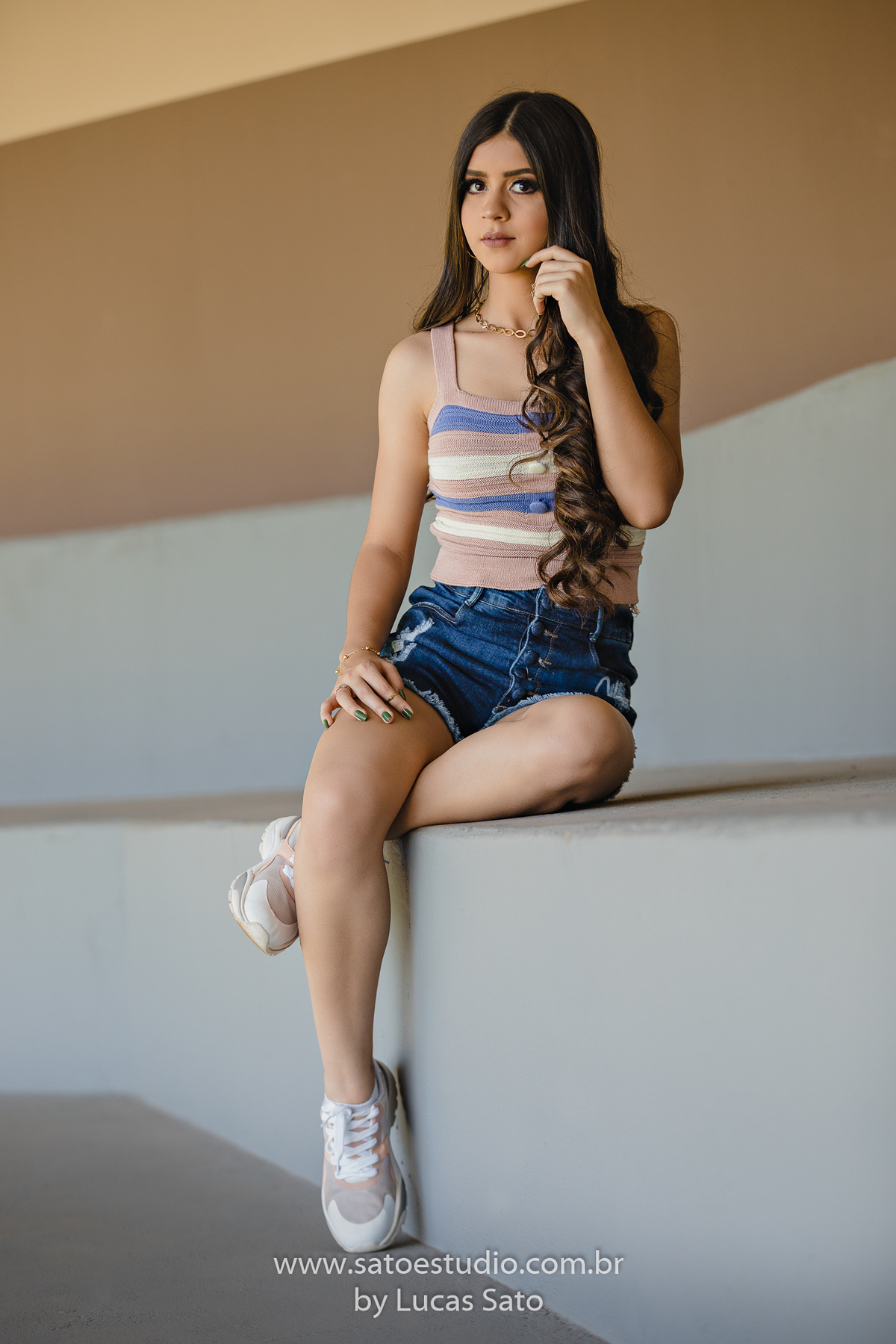 Ensaio 15 anos na arquibancada do Clube Campestre, com shorts jeans e blusa listrada. Book de 15 anos no clube localizado no município de São Gotardo-MG