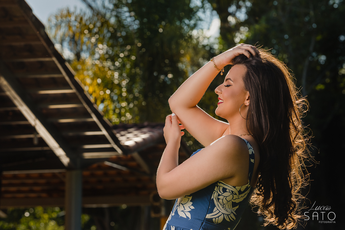 Pose de foto de ensaio 15 anos com vestido azul e sol nos cabelos. Fotografia de ensaio de 15 anos realizado em São Gotardo-MG