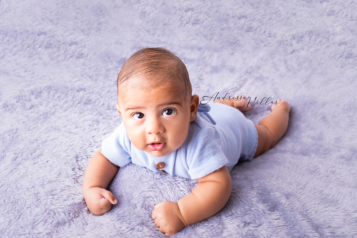 Gustavo deitado de barriga para baixo, com cabeça levantada apoiado nos cotovelos
