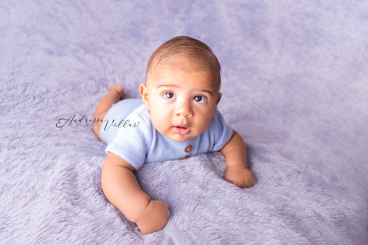 Gustavo deitado de barriga para baixo, com cabeça levantada apoiado nos cotovelos